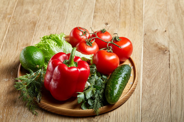 Organic closeup still life of assorted fresh vegetables and herbs on rustic wooden background, topview, selective focus.