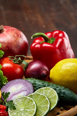 Still life of fresh organic vegetables on wooden plate over wooden background, selective focus, close-up
