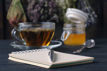 Recipe of healing herbal tea with open notebook