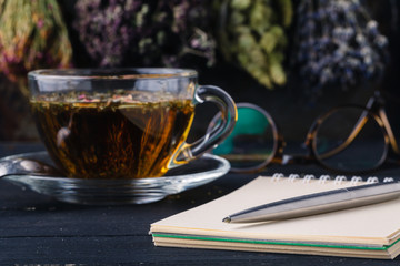 Recipe of healing herbal tea with open notebook