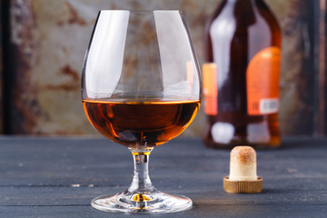 Glass of cognac on rustic ferruginous background