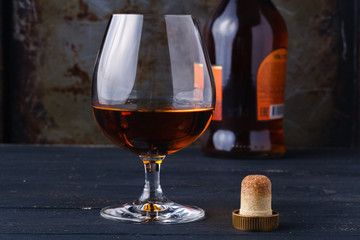 Glass of cognac on rustic ferruginous background
