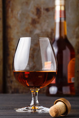 Close up of glass cognac or whiskey on rusty background