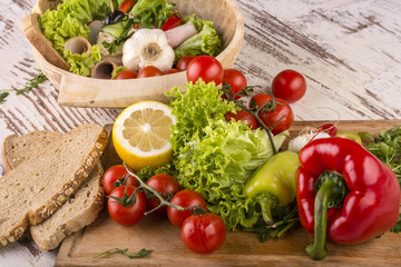 Vegetables, bread and lemons to prepare meals in a wooden bowl
