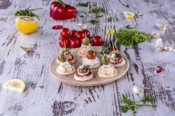 Canape prepared and served on a wooden plate with tomato parsley