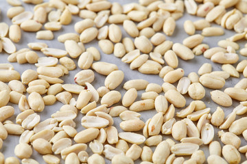 Pile of peelled peanuts isolated on white textured background, background, top view, close-up, selective focus