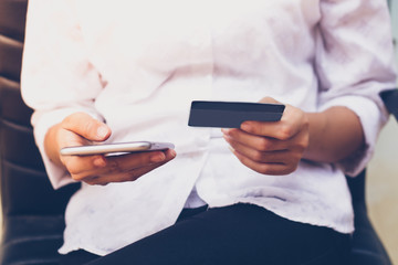 woman asian using phone and credit card shopping online , selective focus on hand