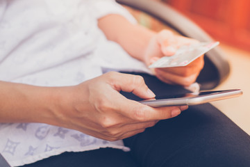 woman asian using phone and credit card shopping online , selective focus on hand