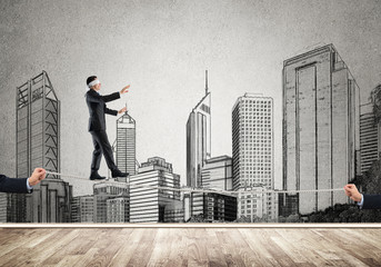 Business concept of risk support and assistance with man balancing on rope