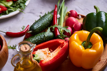 Creative fresh vegetable salad with ruccola, cucumber, tomatoes and raddish on white plate, selective focus