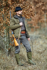 Hunter with gun in the forest