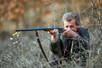 Fototapeta premium Hunter with gun in the forest