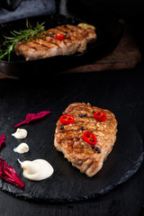 Grilled pork steak on slate plate.