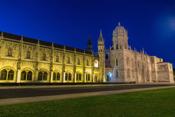 Fototapeta premium Facade of the Jeronimos (Hieronymites) Monastery in the Belem district of Lisbon illuminated at night
