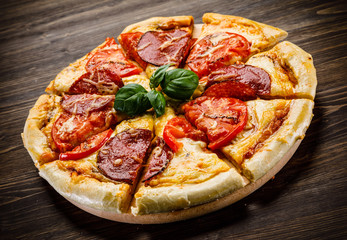Pizza salami on wooden background