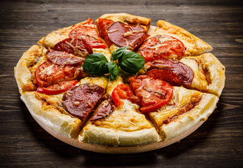 Pizza salami on wooden background