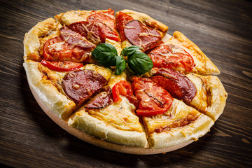 Pizza salami on wooden background