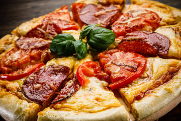 Pizza salami on wooden background