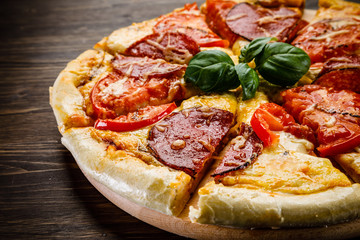 Pizza salami on wooden background