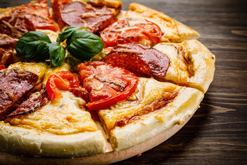 Pizza salami on wooden background