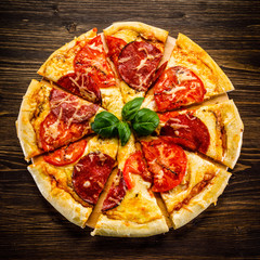 Pizza salami on wooden background