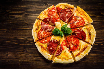 Pizza salami on wooden background