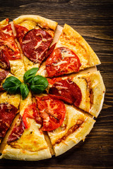 Pizza salami on wooden background