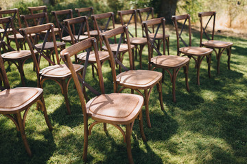 wooden chairs stand on green hill in the wedding ceremony area against the background of Tuscany landscapes
