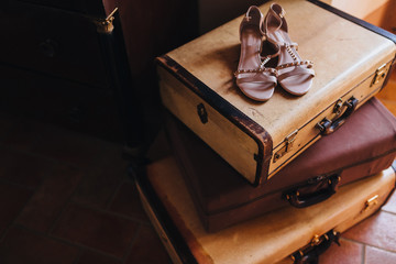 in the room on the floor old suitcases are stacked, on top are women's shoes