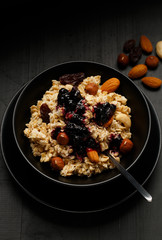 Breakfast: Oatmeal with almonds, hazelnuts, raisins and blueberry jam. Top view