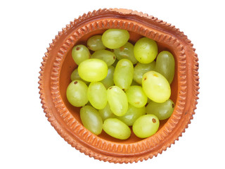 Grapes held in a decorated hand made clay bowl isolated against white background