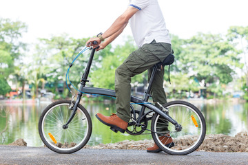 Man with cargo pants riding a bicycle in the garden
