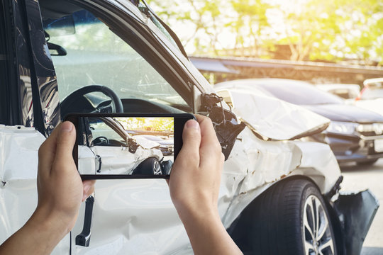 A Man Photographed His Vehicle With Accidental Damage With A Smart Phone.Car Insurance Concept