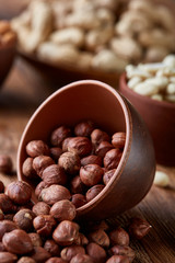 A composition from different varieties of nuts in a wooden bowls on rustic background, close-up, shallow depth of field