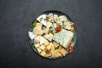 various types of cheese in dark plate