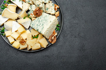 various types of cheese in dark plate