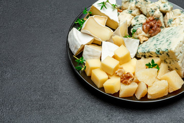 various types of cheese in dark plate