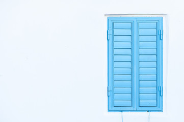 Blue window shutters on a white wall. Space for text