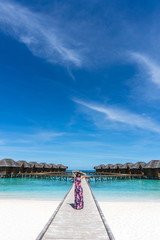 Woman on bridge on beach in Maldives