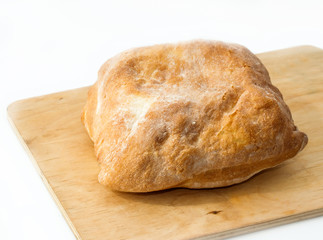 Fresh baked ciabatta italian bread close-up on wooden board isolated on white background