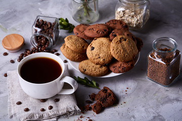Breakfast background with mug of fresh coffee, homemade oatmeal cookies, grind coffee