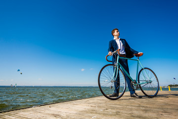 Fototapeta premium Young man standing with bike on pier