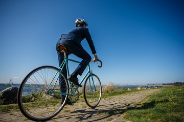 Naklejka na ściany i meble Businessman cycling at seaside