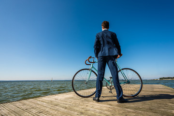 Fototapeta premium Young man standing with bike on pier