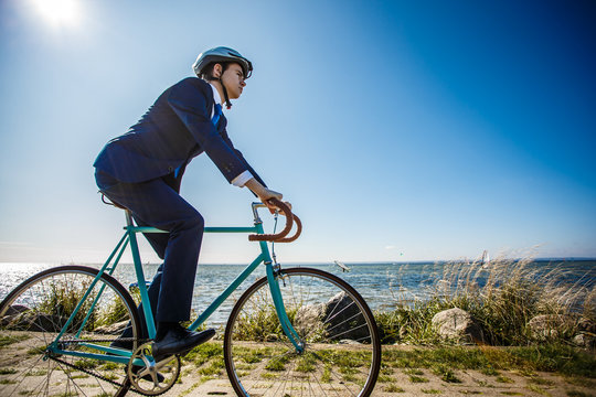 Businessman cycling at seaside