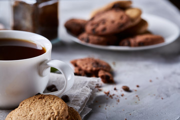 Breakfast background with mug of fresh coffee, homemade oatmeal cookies, grind coffee