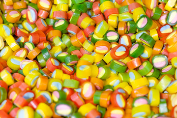 Multicolored candies in store as background, texture (shallow depth of field)