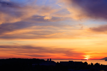 Amazing colors of sunset in the port with reflections of calm sea - focus is on the horizon