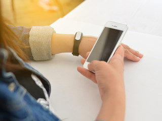 Close-up portrait of a girl using a fitness tracker or heart rate monitor. View the number of steps per day. Fitness concept. A woman looks at the results of training on a fitness bracelet. 