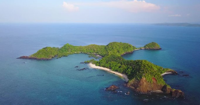 Aerial view of a desert island with a clear and transparent sea and a pristine beach. Concept of: holidays, maldives, dream landscapes.